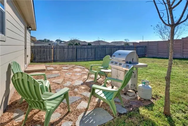 a view of a chairs and table in the backyard