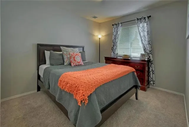 a bed sitting in a bedroom next to a window