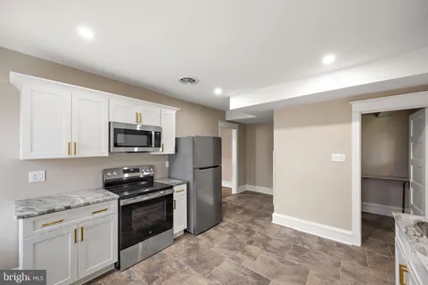 a kitchen with stainless steel appliances granite countertop a refrigerator stove and microwave