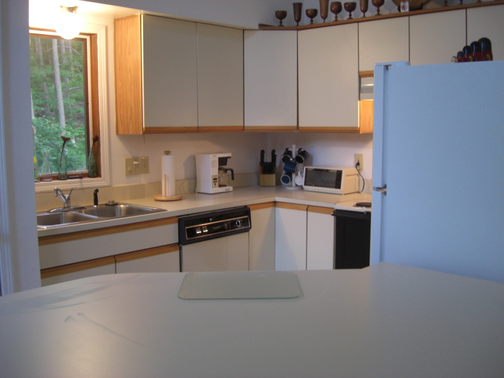 564 Leonhardt Road Becket, MA 01223 - Photo 10 of 11 a kitchen with stainless steel appliances granite countertop a sink a stove a refrigerator with grey cabinets and a window