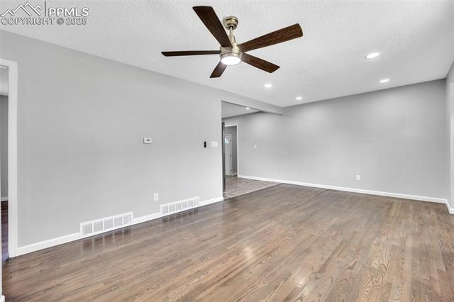 2004 Monterey Road Colorado Springs, CO 80910 - Photo 6 of 27 Empty room with ceiling fan, recessed lighting, wood finished floors, and a textured ceiling