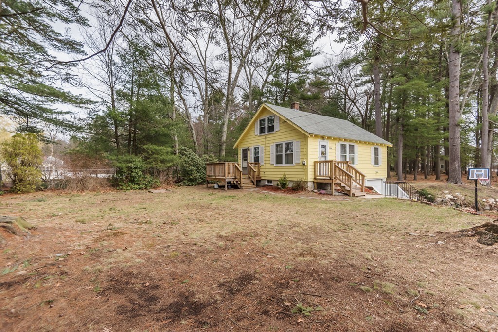338 Andover Road Billerica, MA 01821 - Photo 3 of 16 a view of a house with a yard covered in the forest