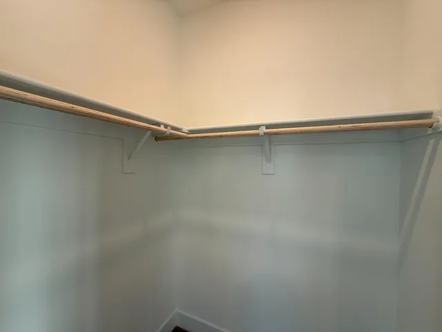 a view of walk in closet with empty racks