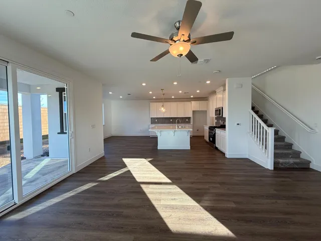 a view of a living room with wooden floor and a fireplace