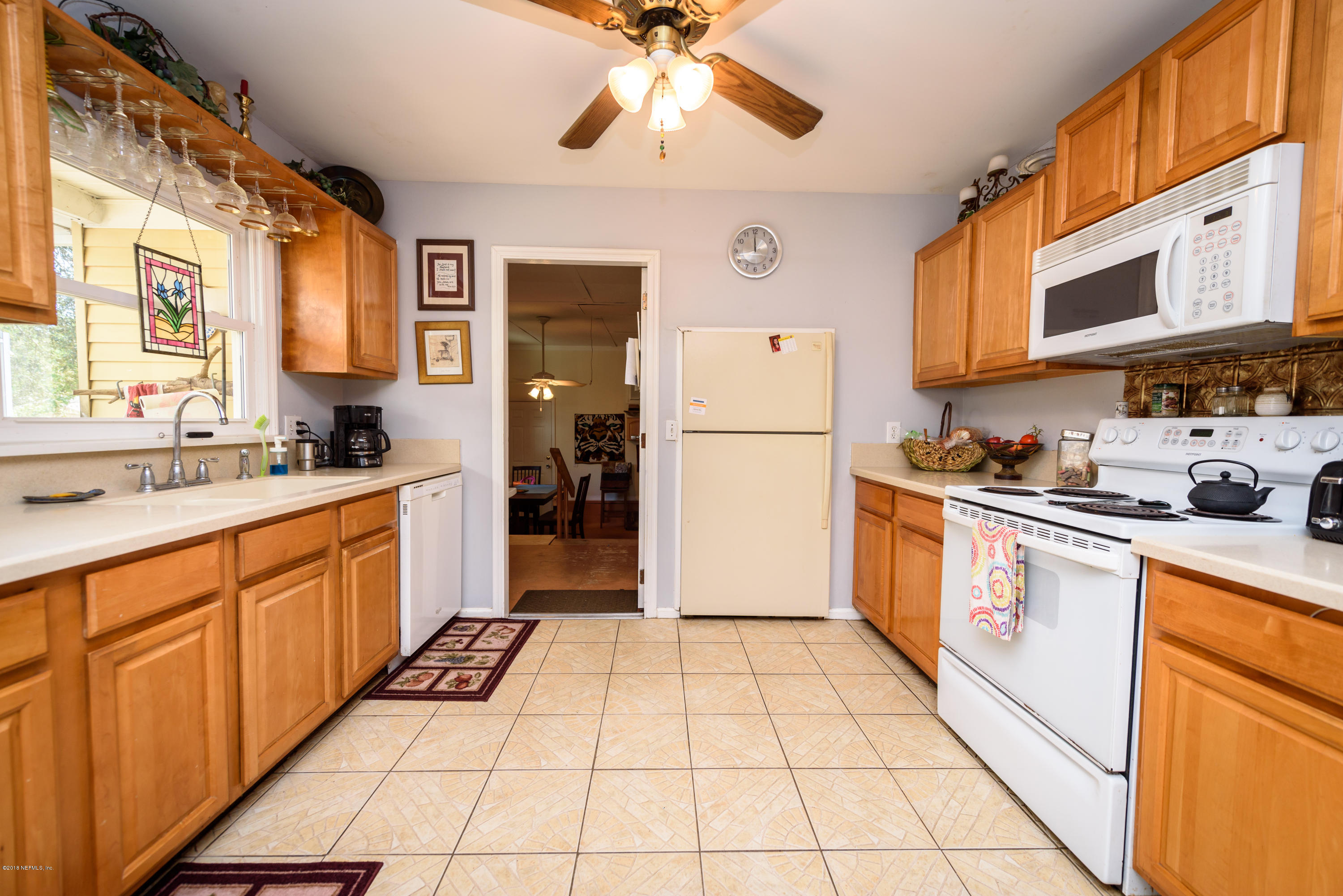 249 Bonita Road St. Augustine, FL 32086 - Photo 18 of 46 a kitchen with stainless steel appliances granite countertop a refrigerator a sink dishwasher a stove with wooden cabinets and floor