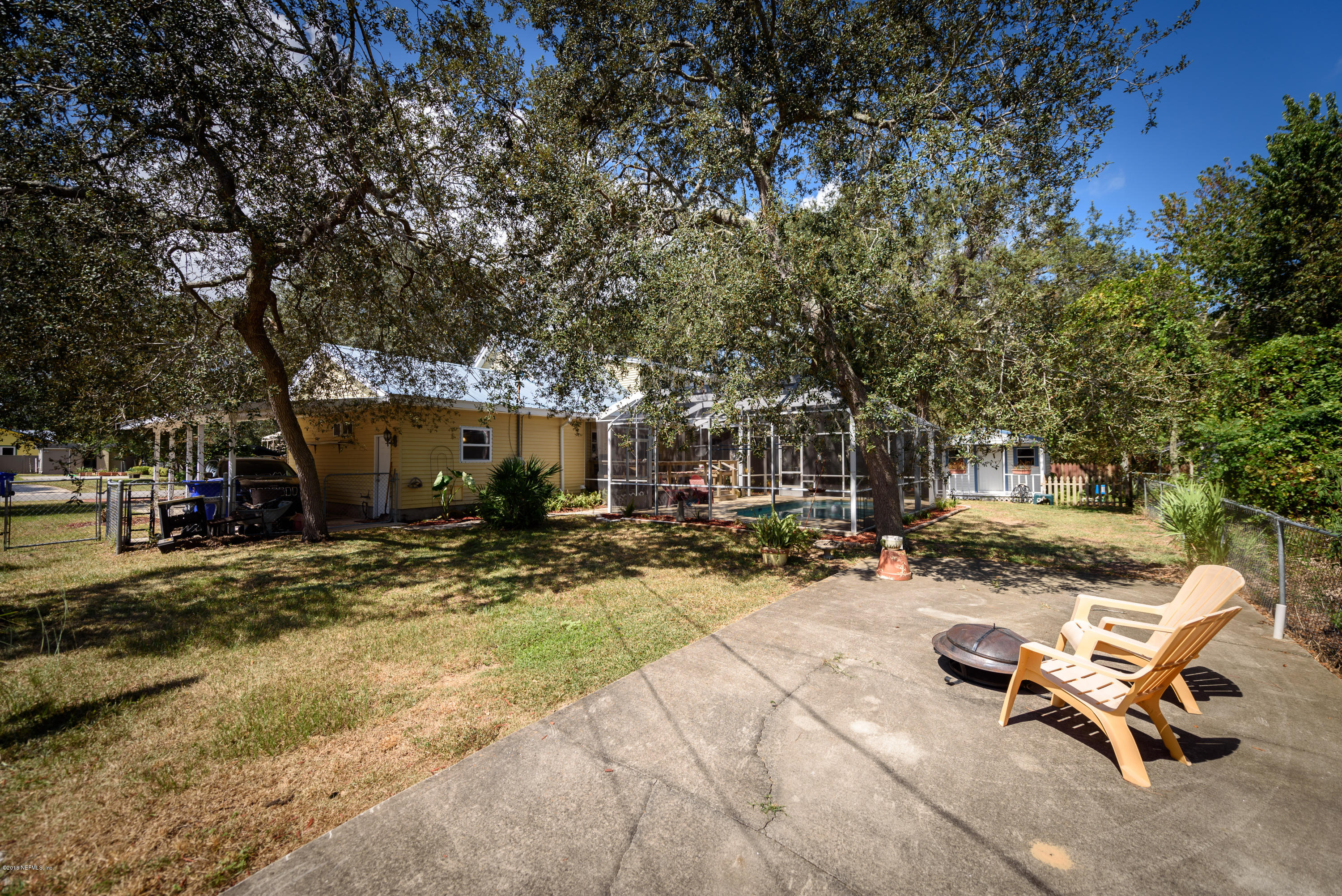 249 Bonita Road St. Augustine, FL 32086 - Photo 41 of 46 a view of a backyard with table and chairs and a fire pit