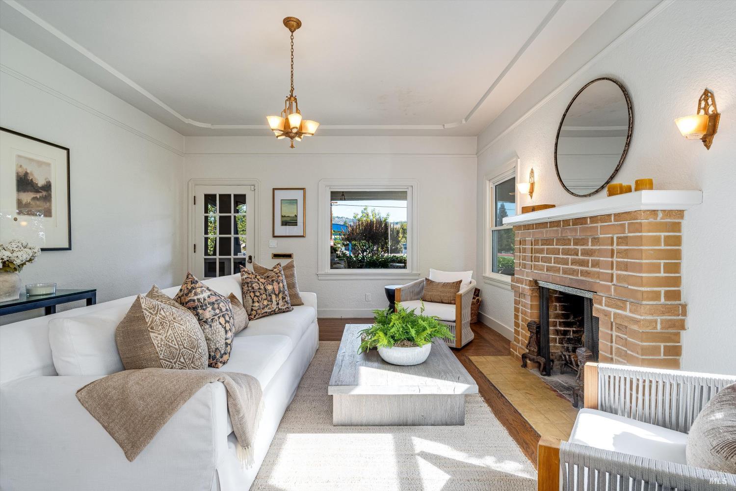 1709 Spring Mountain Road St. Helena, CA 94574 - Photo 11 of 48 a living room with furniture a fireplace and a chandelier