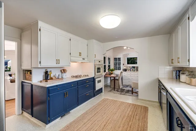 a kitchen with granite countertop a sink stove and cabinets