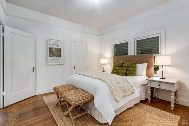 a bedroom with a bed wooden floor and lamp