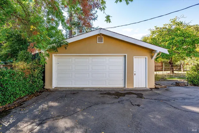 a view of a white house with large outdoor space and a street view
