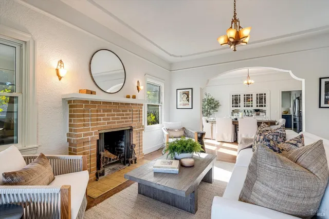 a living room with furniture a fireplace and a chandelier