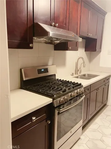 a kitchen with granite countertop a stove and a sink