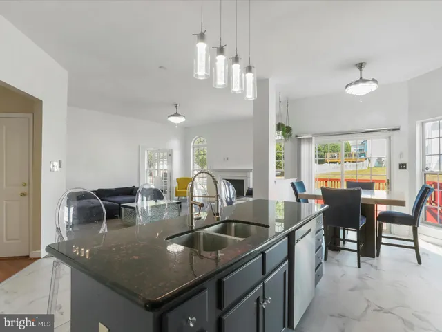 a kitchen with stainless steel appliances granite countertop a sink and a refrigerator