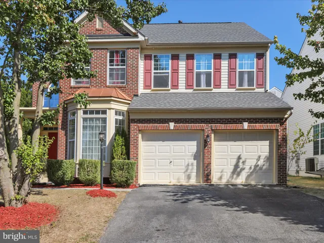 a front view of a house with a yard and a garage