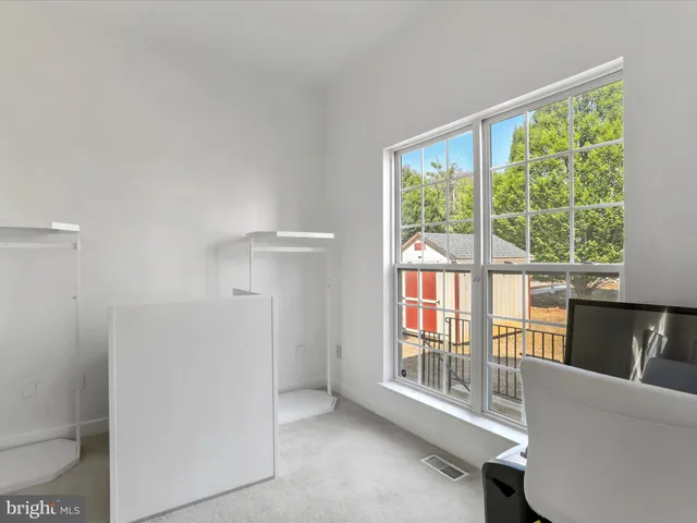 an empty room with a window and a fan