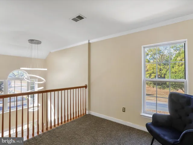 a view of an empty room with a chandelier fan