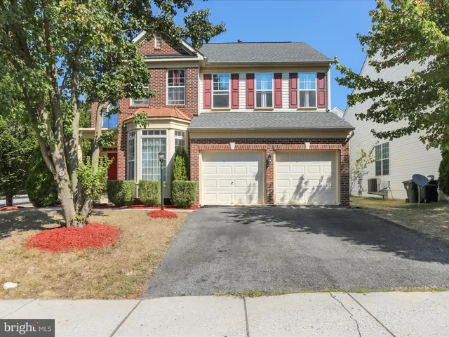a front view of a house with a yard and a garage