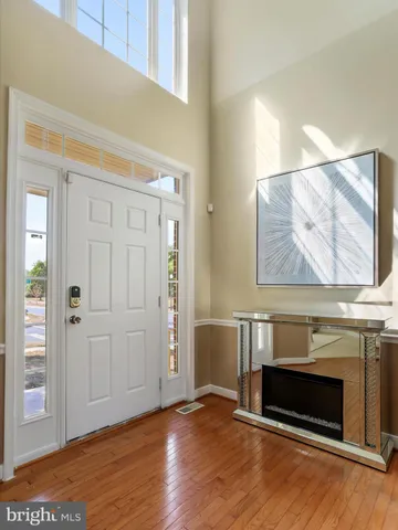 an empty room with wooden floor fireplace and windows