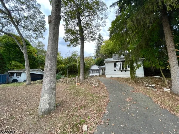 a view of a house with backyard and a tree