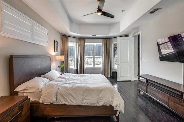 a bedroom with a bed wooden floor and window
