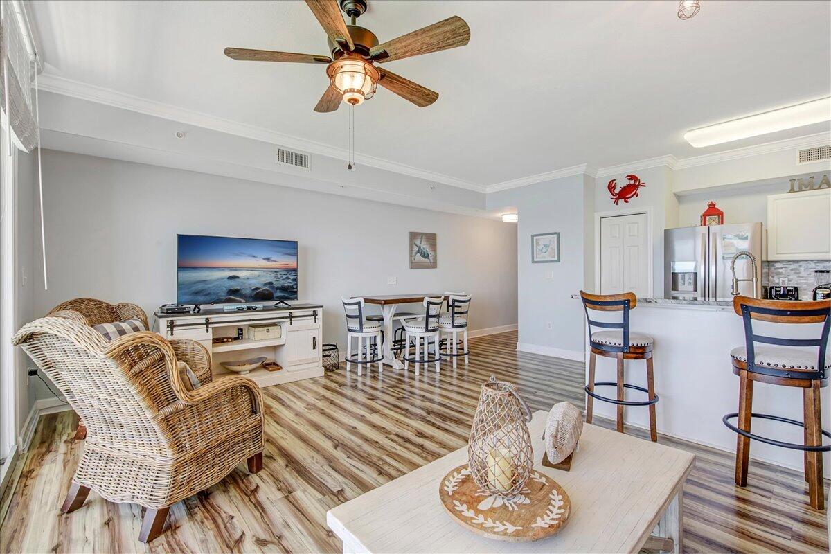 16819 Front Beach Road, Unit 2210 Panama City Beach, FL 32413 - Photo 3 of 30 a living room with furniture a flat screen tv and kitchen view