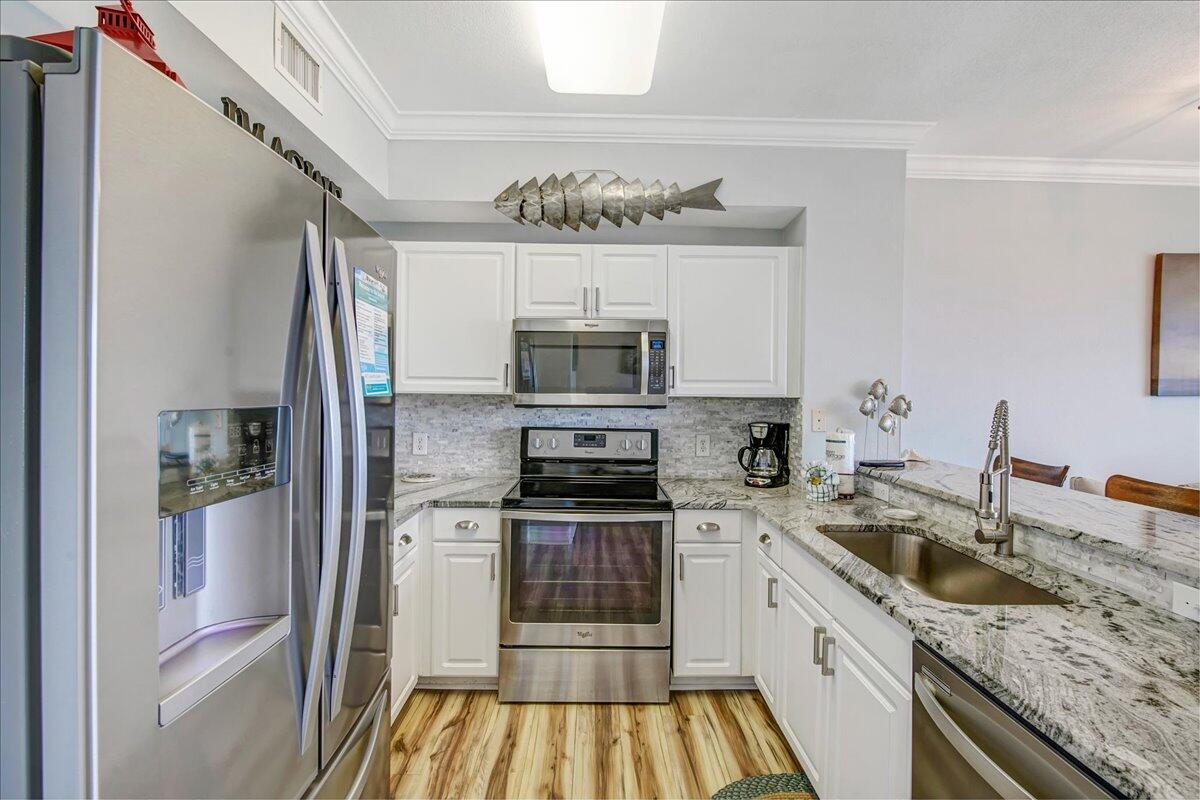 16819 Front Beach Road, Unit 2210 Panama City Beach, FL 32413 - Photo 8 of 30 a kitchen with a sink stove and refrigerator