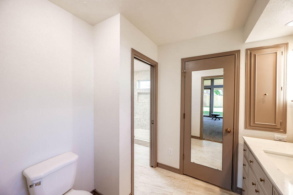 4106 64th Street Lubbock, TX 79413 - Photo 13 of 60 a bathroom with a toilet a sink and shower