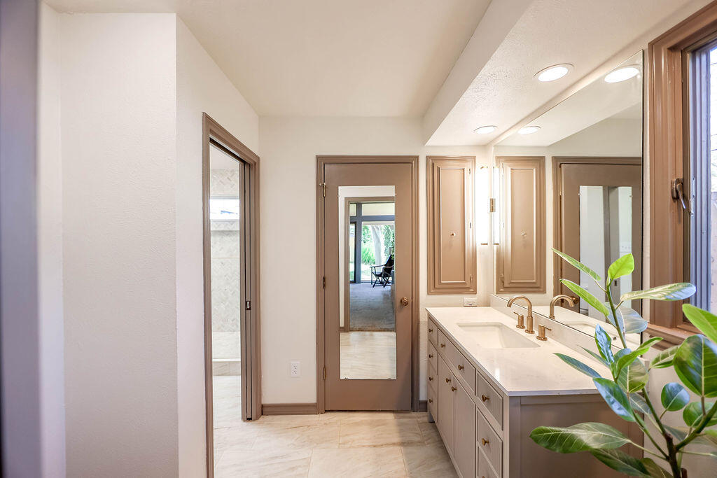 4106 64th Street Lubbock, TX 79413 - Photo 14 of 60 a spacious bathroom with a double vanity sink and a mirror