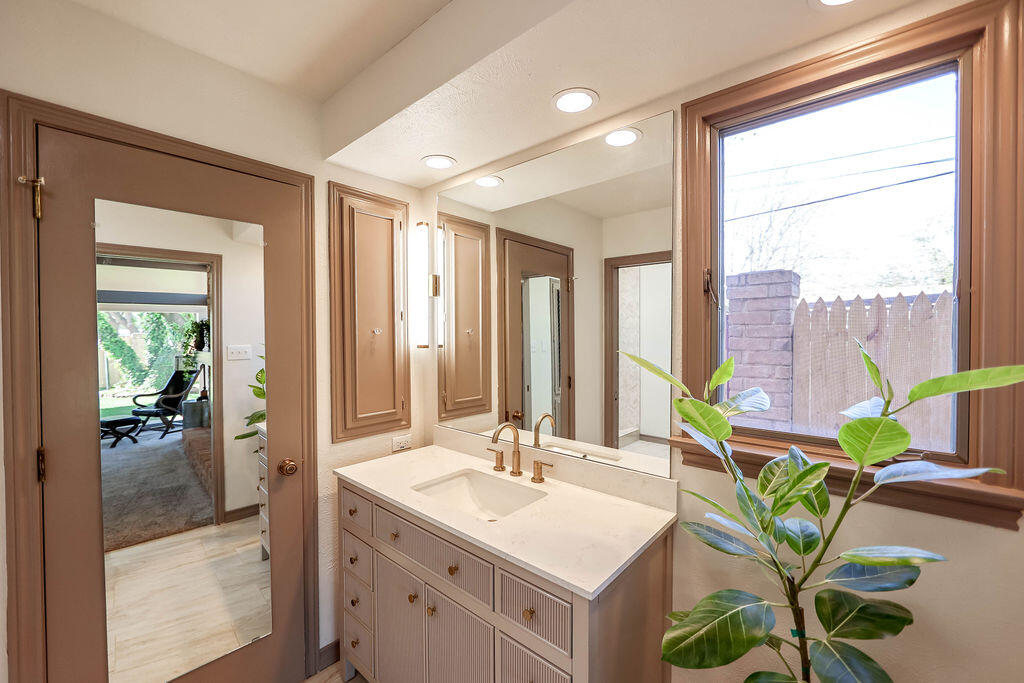 4106 64th Street Lubbock, TX 79413 - Photo 15 of 60 a spacious bathroom with a sink a mirror and a shower
