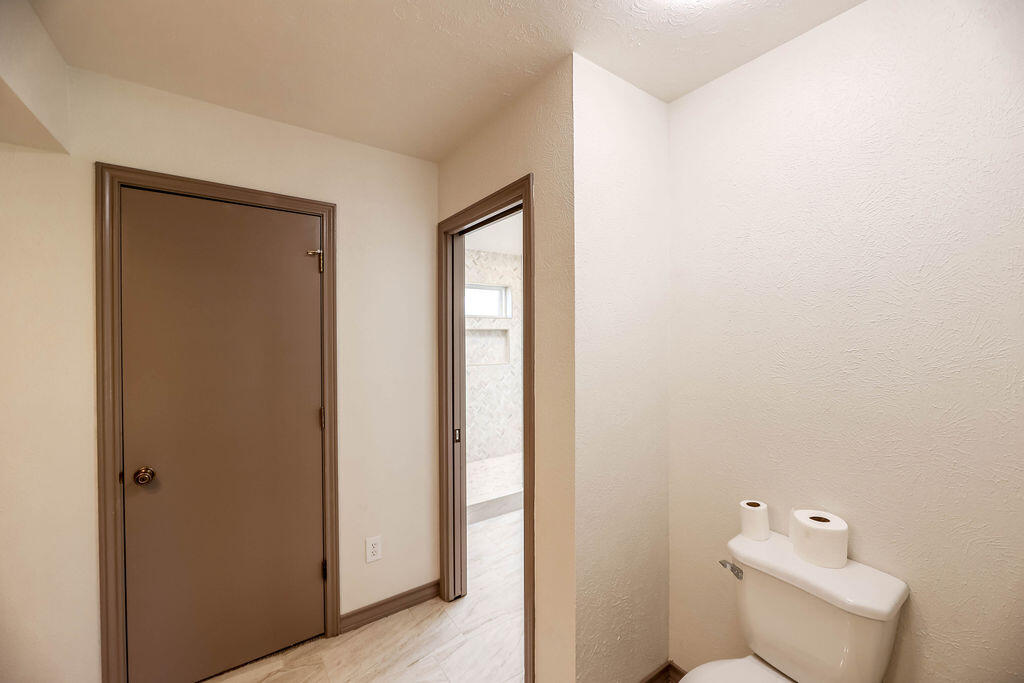 4106 64th Street Lubbock, TX 79413 - Photo 20 of 60 a white toilet sitting next to a bathroom sink