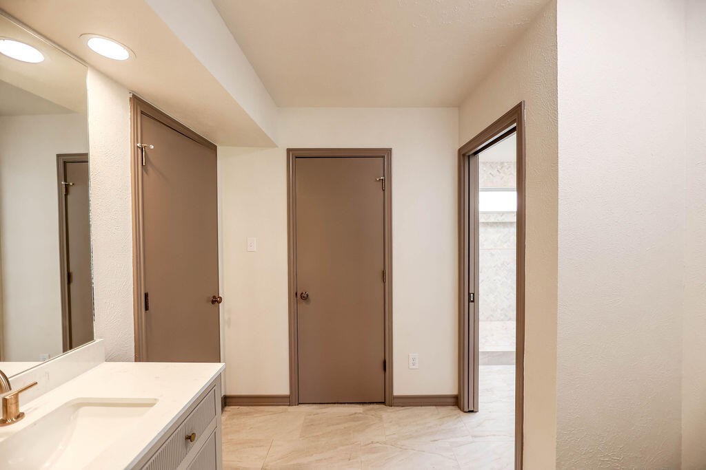4106 64th Street Lubbock, TX 79413 - Photo 21 of 60 a en suite bathroom with a granite countertop sink and a mirror