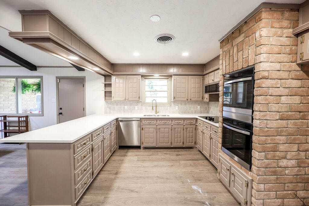 4106 64th Street Lubbock, TX 79413 - Photo 26 of 60 a large kitchen with stainless steel appliances kitchen island granite countertop a large stove a sink dishwasher and a refrigerator