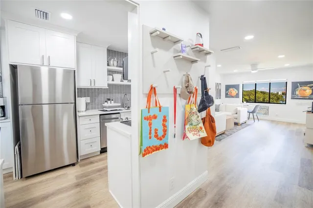 a view of a kitchen with fridge and wooden floor