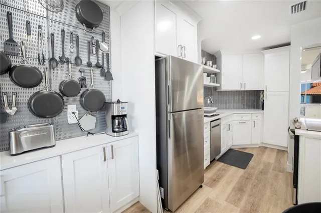 a kitchen with stainless steel appliances granite countertop a refrigerator and a stove