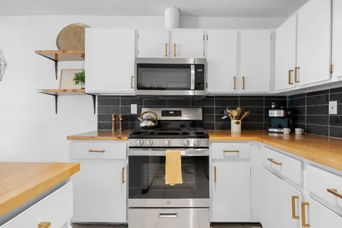 a kitchen with stainless steel appliances a refrigerator and a stove top oven