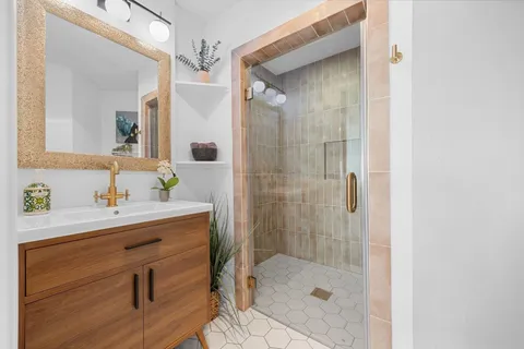 a bathroom with a glass shower door and a mirror