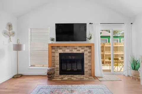 a living room with a fireplace and potted plants