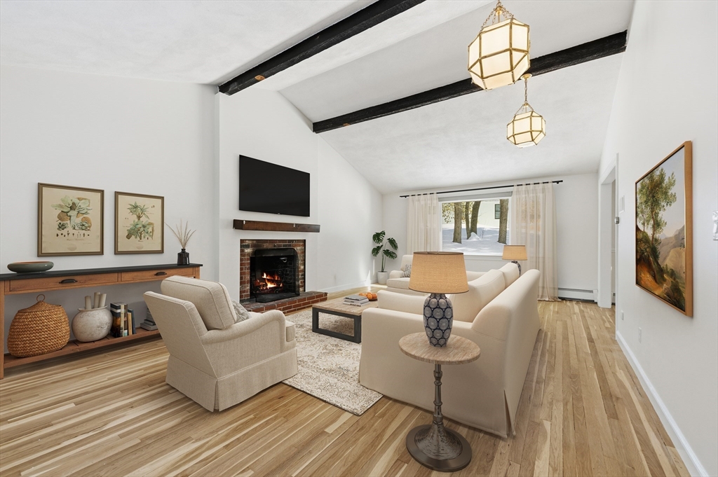 124 Everett Street Natick, MA 01760 - Photo 7 of 26 a living room with furniture a flat screen tv and a fireplace