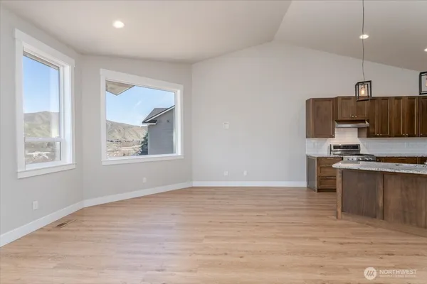 a view of kitchen with stainless steel appliances cabinets and wooden floor