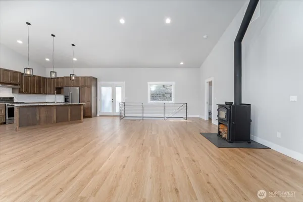 a view of kitchen with cabinets wooden floor and stainless steel appliances