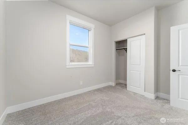 an empty room with windows and closet