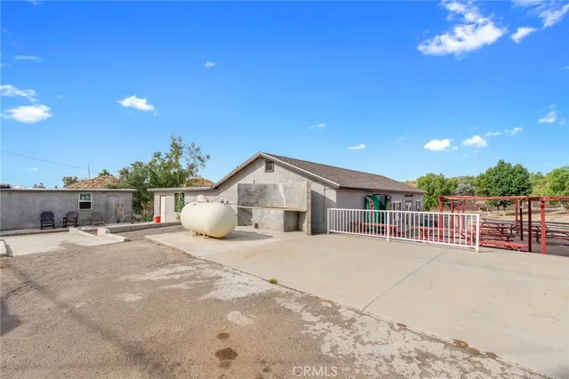 a kitchen with stainless steel appliances kitchen island granite countertop a refrigerator oven a sink a dining table and chairs with wooden floor