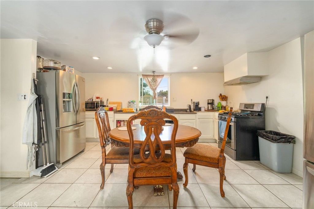 21871 Richard Street Perris, CA 92570 - Photo 69 of 75 a kitchen with stainless steel appliances kitchen island granite countertop a refrigerator oven a sink a dining table and chairs with wooden floor