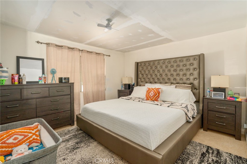 21871 Richard Street Perris, CA 92570 - Photo 71 of 75 a bedroom with a bed a dresser and painting on the wall