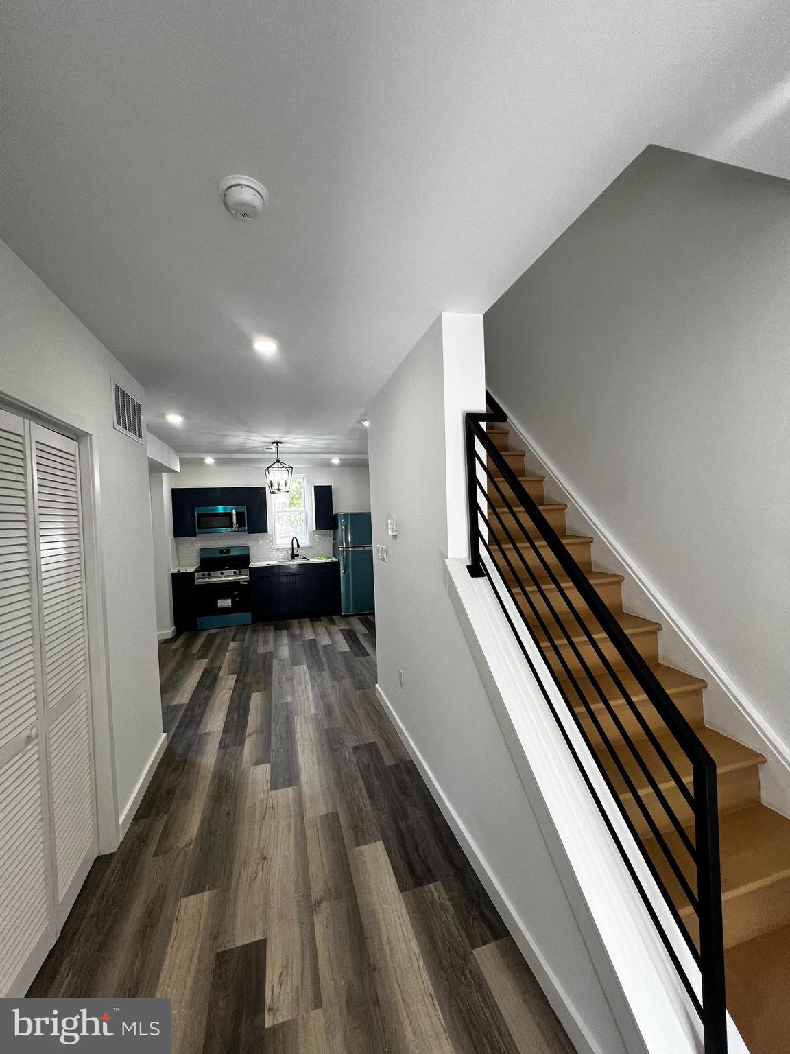 a view of kitchen with sink and refrigerator