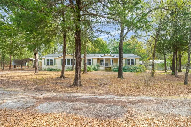a front view of a house with a yard and trees