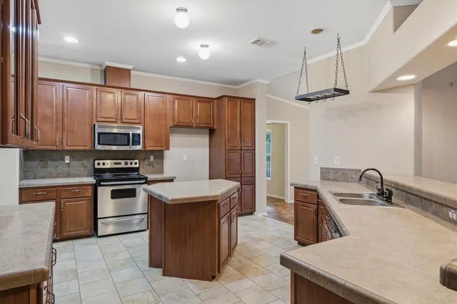 a kitchen with stainless steel appliances granite countertop a sink and a stove