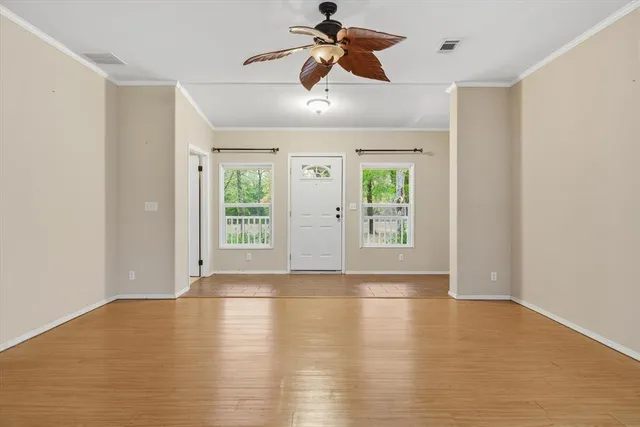 a view of empty room with windows and ceiling fan