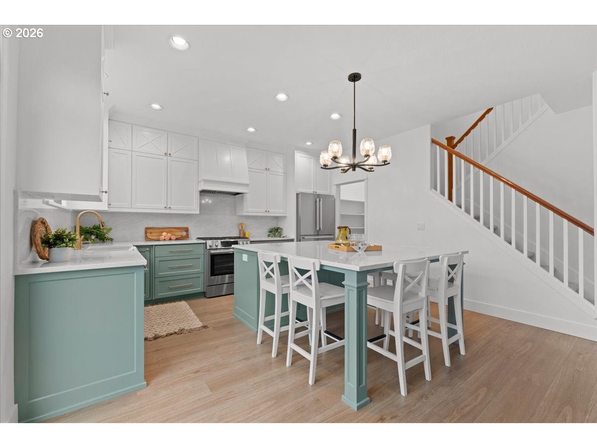 11595 Southwest Butte Lane Beaverton, OR 97008 - Photo 13 of 48 a view of a dining room with furniture a chandelier and wooden floor