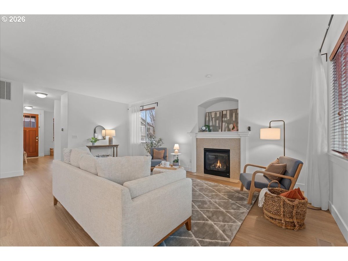 11595 Southwest Butte Lane Beaverton, OR 97008 - Photo 2 of 48 a living room with furniture a fireplace and a large window
